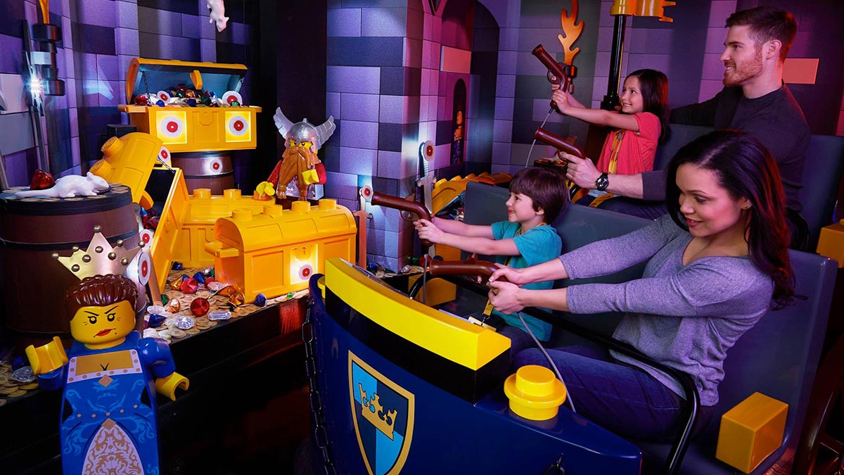 family of four aboard Kingdom Quest Laser Ride at Legoland in Atlanta, Georgia, USA